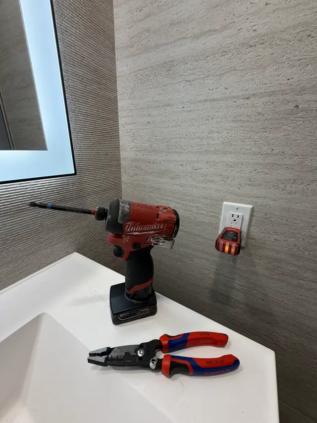Tools on a vanity next to a newly installed outlet