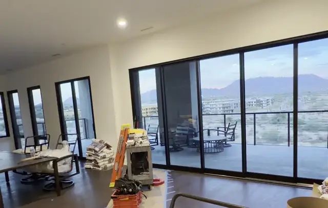 Remodel near completion, recessed lighting in a living room with floor-to-ceiling windows and a mountain view